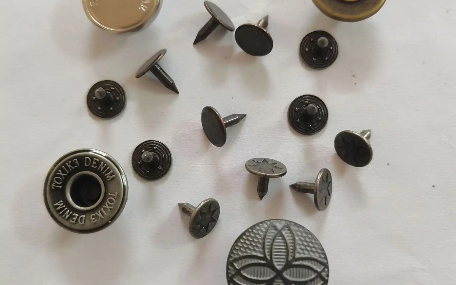 Antique brass and gunmetal jeans buttons with custom logo stamping