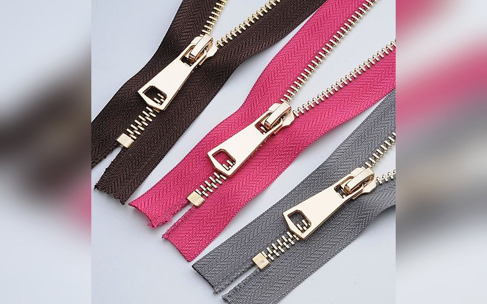 Metal zippers with custom pullers in black, pink and grey